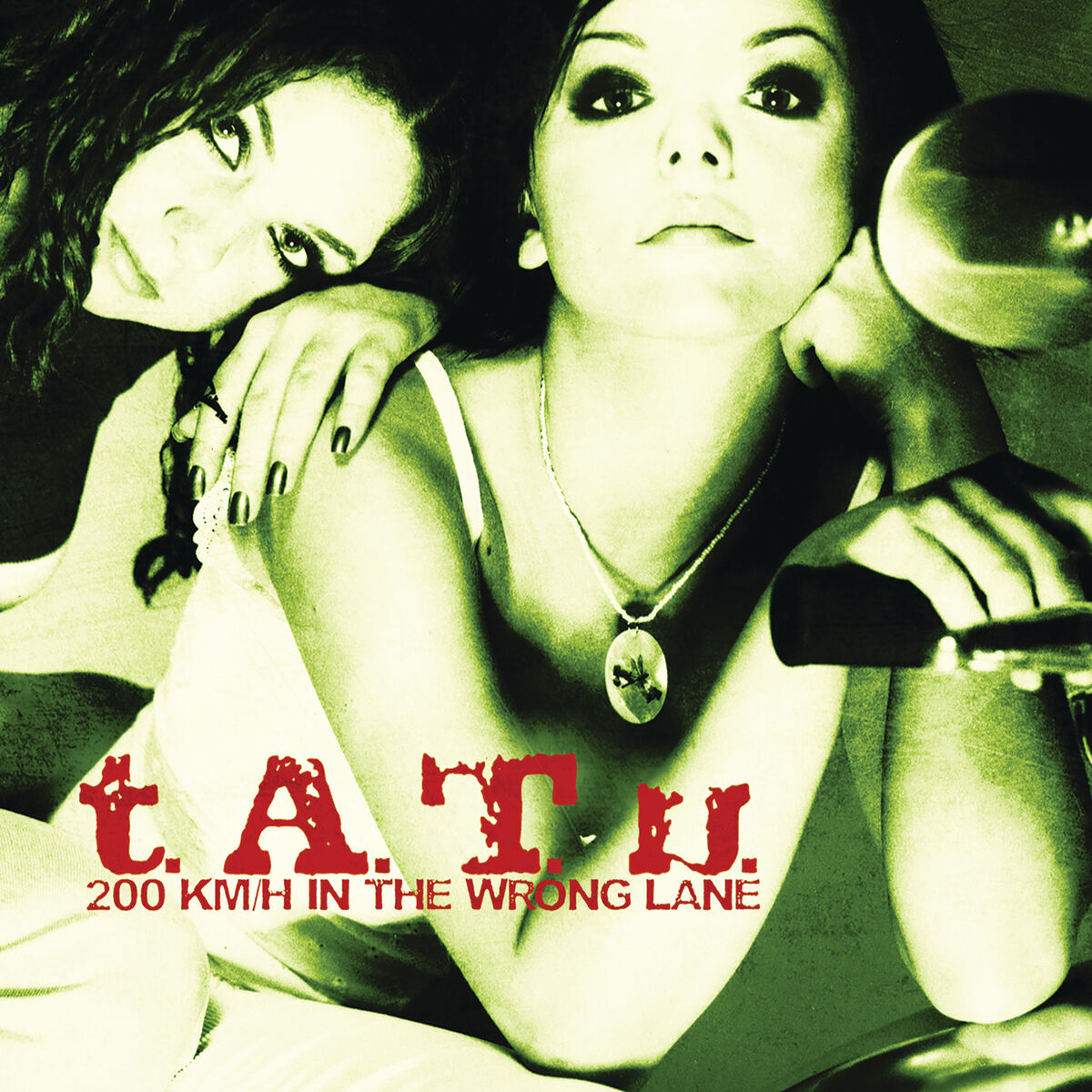 La portada del disco de Tatu 200 km/h in the wrong lane. Hay una chica pelirroja apoyada en el hombro de una chica morena de pelo corto, que a su vez est&aacute; apoyada en el manillar de una moto. Todo tiene un tinte verdoso.